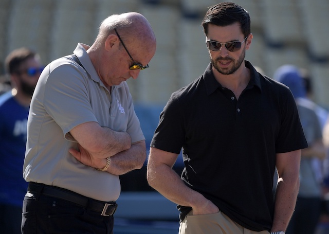 Los Angeles Dodgers president and CEO Stan Kasten speaks with vice president and assistant general manager Brandon Gomes before a game at Dodger Stadium