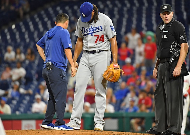 Los Angeles Dodgers closer Kenley Jansen is checked on by a trainer after being hit by a comebacker