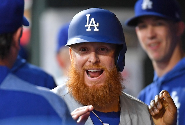 Los Angeles Dodgers pitcher Walker Buehler looks on as Justin Turner is congratulated in the dugout